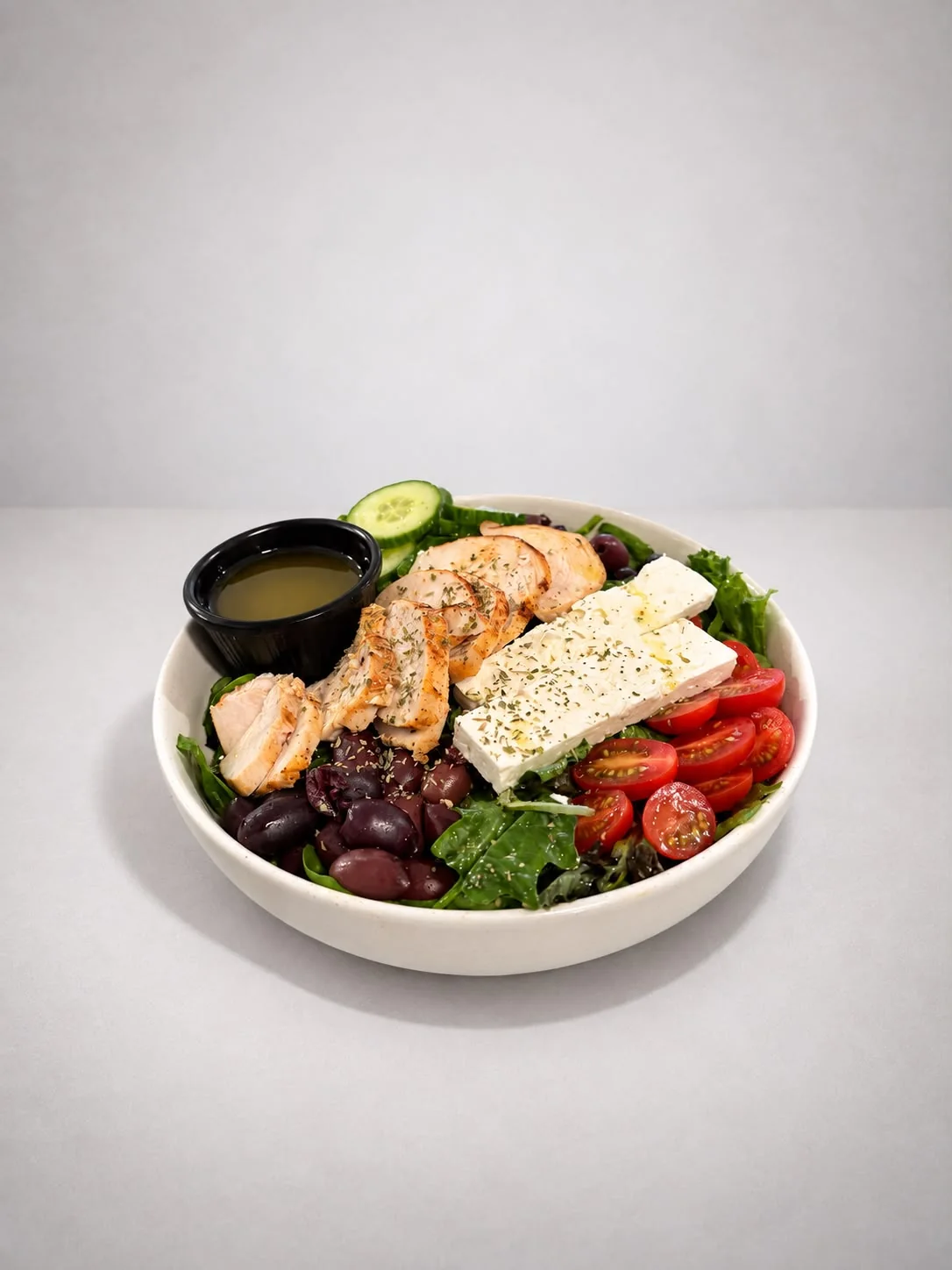Greek salad with chicken, feta, olives and tomato